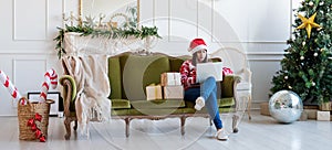 Young woman sitting on couch in a decorated living room working on laptop computer