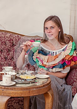 Young woman sitting on a couch and drinking tea