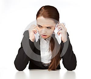 Young woman sitting at a desk, with grimace of anger