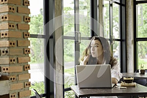 Young woman sitting at desk working with laptop computer at home