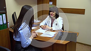 Young woman sitting in a doctor`s office. The doctor gives recommendations.