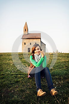 Young woman is sitting in front of the church