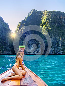 Young woman sitting at the front of longtail boat cruising Phi Phi Leh Island, Krabi Province, Thailand