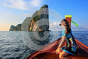 Young woman sitting in the front of a longtail boat going to Phi