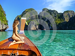 Young woman sitting at the front of longtail boat in Maya Bay on