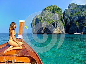 Young woman sitting at the front of longtail boat in Maya Bay on