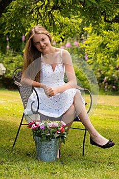 Young woman sitting in garden with flowers