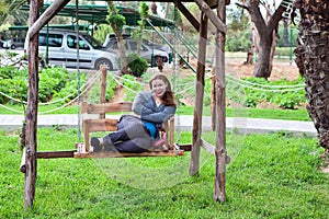 Young woman sitting on the garden swing