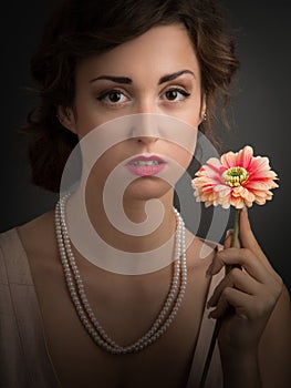 Young woman sitting with a gerber a flower