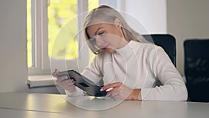 Young woman sitting at her desk she`s drawing, writing and using pen with digital tablet computer.