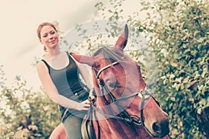 Young woman sitting on a horse