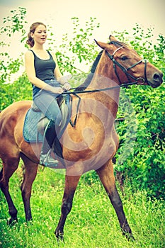 Young woman sitting on a horse