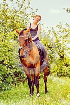 Young woman sitting on a horse