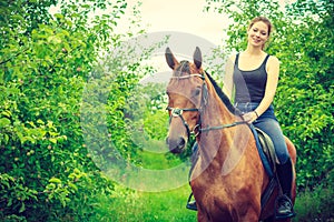 Young woman sitting on a horse