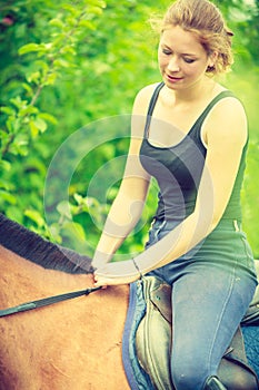 Young woman sitting on a horse