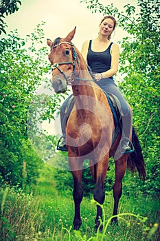 Young woman sitting on a horse