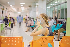 Young woman sitting in hospital waiting for a doctor`s appointment. Patients In Doctors Waiting Room photo