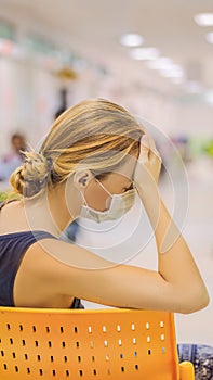 Young woman sitting in hospital waiting for a doctor`s appointment. Patients In Doctors Waiting Room VERTICAL FORMAT for