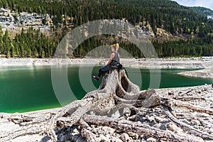 Young Woman Sitting on Huge roots of old trees on Gosausee Vorderer lake