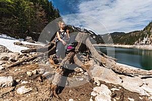 Young Woman Sitting on Huge roots of old trees on Gosausee Vorderer lake