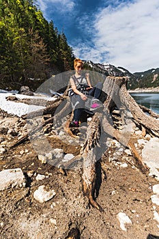 Young Woman Sitting on Huge roots of old trees on Gosausee Vorderer lake