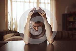 Young woman sitting hugging her head