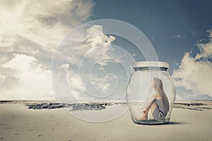 Young woman sitting in a jar in the desert. Loneliness outlier concept