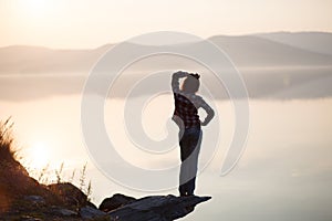 Young woman sitting by the lake