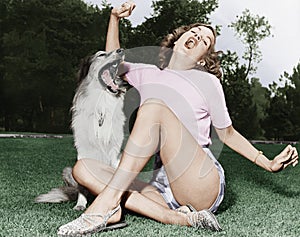 Mujer joven sobre el césped cantando su el perro 
