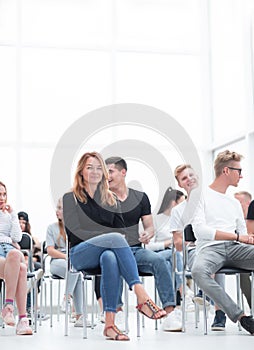 young woman sitting among the listeners of the business seminar