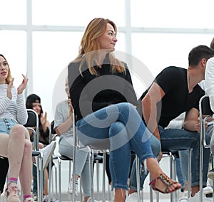 young woman sitting among the listeners of the business seminar