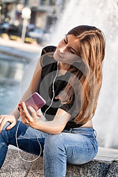 Young woman sitting and listening to her music