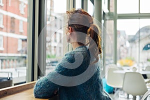 Young woman sitting looking out the window