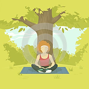 Young woman sitting in a lotus position with a book in nature. Reading, studying, relaxing. Lush greenery in the background. photo