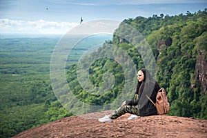 Young woman sitting on a mountain top