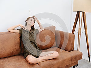 Young woman sitting on an orange couch at home surprise and smile with teeth full, summer, happy vacation home vacations