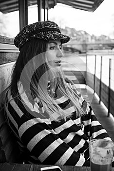 young woman sitting at the restaurant terace on boat floating on the river