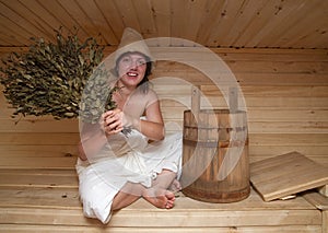 Young woman is sitting at sauna bath