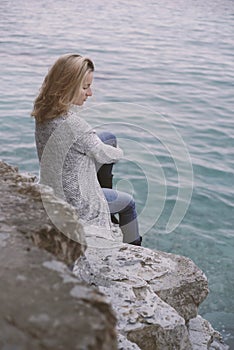 Young Woman sitting on seacoast