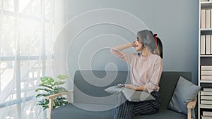 Young woman sitting on the sofa listening to music chilling and smiling relax