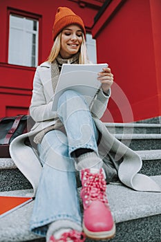 Young woman sitting on stairs with copybook