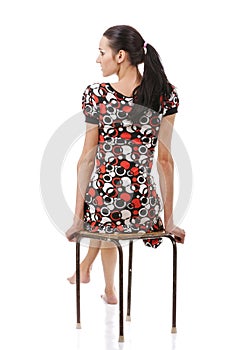 Young woman sitting on stool