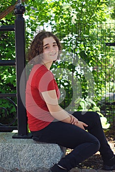 Young woman sitting student frizz hairstyle outdoor smiling portrait