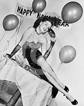 Young woman sitting on a table with balloons and sign