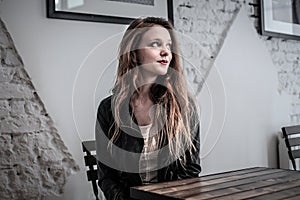 Young woman sitting at a table waiting