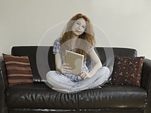 Young woman sitting with a tablet in the center of