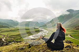 Young Woman Sitting On The Top Of The Mountain In Meditation Session In Lotus Posture On Picturesque Summer Mountain Landscape Bac