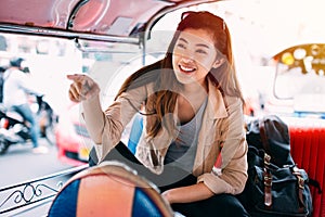 Young woman sitting at tuk tuk in Bangkok, Thailand