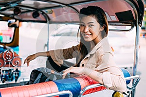 Young woman sitting at tuk tuk in Bangkok, Thailand