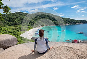 Young woman sitting on viewpoint sailing rock